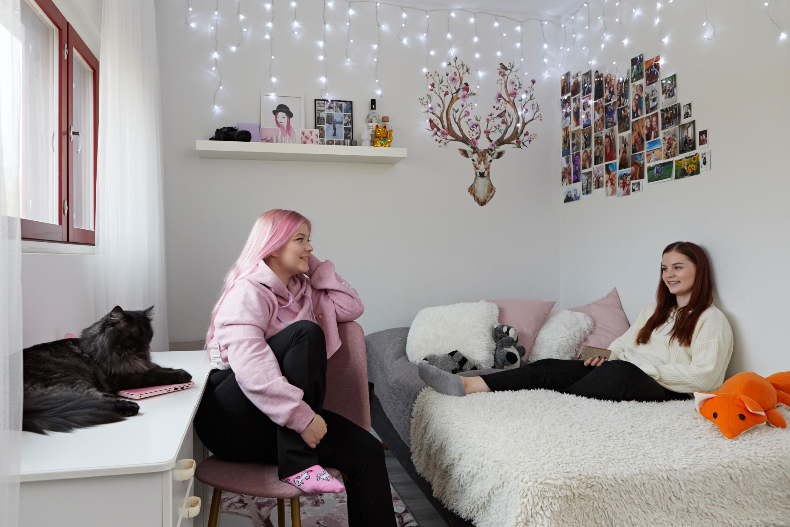Huoneen sisustuksessa on valokuvakokoelma ja valonauha ja seinätarra.